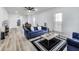 Bright living room features a tufted blue sofa, stylish rug, and modern decor, perfect for relaxing and entertaining at 44 S Tremont St, Indianapolis, IN 46222