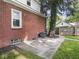 Brick home exterior featuring a concrete patio and a mature tree in a fenced backyard at 4523 Kingsley Dr, Indianapolis, IN 46205