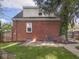 Brick house exterior with a concrete patio, mature tree, and a fenced backyard at 4523 Kingsley Dr, Indianapolis, IN 46205