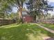Lush backyard featuring mature trees, a grassy lawn, and a brick home exterior with fencing at 4523 Kingsley Dr, Indianapolis, IN 46205