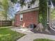 Brick home exterior with a large tree and a concrete patio in a fenced backyard at 4523 Kingsley Dr, Indianapolis, IN 46205