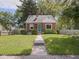 Charming brick home with a well-manicured lawn, complemented by mature trees and a welcoming walkway to the front door at 4523 Kingsley Dr, Indianapolis, IN 46205