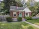 Charming brick home features a cozy covered porch and a well maintained yard at 4523 Kingsley Dr, Indianapolis, IN 46205