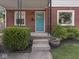 Close-up of a charming front porch with a vibrant blue door, steps, and lush landscaping at 4523 Kingsley Dr, Indianapolis, IN 46205