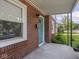Home's exterior featuring a welcoming front porch, brick detail, and a vibrant blue door at 4523 Kingsley Dr, Indianapolis, IN 46205