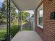 Covered front porch featuring brick detail and view of the landscaped yard at 4523 Kingsley Dr, Indianapolis, IN 46205