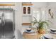 Cozy dining area with stainless steel refrigerator and built in white cabinets with lattice doors at 4523 Kingsley Dr, Indianapolis, IN 46205