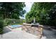 Outdoor kitchen features granite countertops, stainless grill and stone accents, complete with hot tub at 4976 Rockne Cir, Carmel, IN 46033