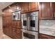 Gourmet kitchen features stainless steel appliances, custom cabinetry, and granite countertops at 4976 Rockne Cir, Carmel, IN 46033