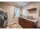 Functional laundry room with sink, cabinets, and modern appliances at 4976 Rockne Cir, Carmel, IN 46033