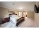 Spacious main bedroom with a decorative bed frame, neutral walls, and ensuite bathroom at 4976 Rockne Cir, Carmel, IN 46033