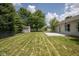 View of the large grassy backyard with a storage shed and concrete patio at 5642 Southern Mist Dr, Indianapolis, IN 46237