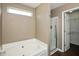 Spacious bathroom with bathtub, walk-in shower, tile surround, and a window for natural light at 5642 Southern Mist Dr, Indianapolis, IN 46237