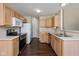 Functional kitchen featuring stainless steel appliances, wooden cabinets, and wood floors at 5642 Southern Mist Dr, Indianapolis, IN 46237