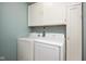 Bright laundry room with white washer and dryer units and white cabinets for storage at 5642 Southern Mist Dr, Indianapolis, IN 46237