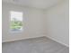 A freshly painted bedroom features neutral carpet and single window overlooking the backyard at 5672 High Timber Ln, Indianapolis, IN 46235