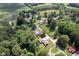 An aerial view showcases the home's location amidst lush trees, green lawns, and nearby fields at 5902 Oak Ln, Anderson, IN 46013