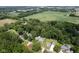 An aerial view showcases the home's location amidst lush trees, green lawns, and nearby fields at 5902 Oak Ln, Anderson, IN 46013
