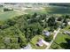 An aerial view highlighting the home's location amidst lush trees, green lawns, and nearby fields at 5902 Oak Ln, Anderson, IN 46013