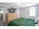 Bedroom features a green bedspread, wood dresser, and cozy ambiance at 5902 Oak Ln, Anderson, IN 46013
