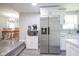 Eat-in kitchen featuring stainless steel refrigerator, microwave, white cabinets, and adjacent dining area at 5902 Oak Ln, Anderson, IN 46013