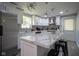 Modern kitchen featuring white cabinetry, stainless steel appliances, and a large marble island with stools at 5902 Oak Ln, Anderson, IN 46013