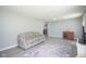 Comfortable living room area with wood-style flooring, floral couch, and open view to dining area at 5902 Oak Ln, Anderson, IN 46013