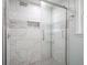 Contemporary walk-in shower with white marble tile and built-in shelving at 5902 Oak Ln, Anderson, IN 46013
