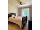 Inviting bedroom with a dark wood bedframe, plush bedding, and bright, natural light from the window at 5993 E County Road 100 S, Avon, IN 46123