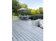 Beautiful gray deck with large dining table, bench seating, and an umbrella for shade at 5993 E County Road 100 S, Avon, IN 46123