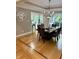 A dining room features a dark wood table set for six, elegant chandelier, hardwood floors and large windows at 5993 E County Road 100 S, Avon, IN 46123