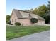 Brick home with a three-car garage, manicured landscaping, and lush green lawn at 5993 E County Road 100 S, Avon, IN 46123