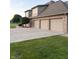 Three-car garage showcasing a concrete driveway, brick accents, and professionally landscaped surroundings at 5993 E County Road 100 S, Avon, IN 46123