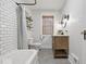 Bright bathroom featuring subway tile, a modern vanity, hexagon tile floor, and natural light at 6009 Ralston Ave, Indianapolis, IN 46220