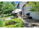 Inviting backyard patio with a water feature, outdoor seating, barbecue grill, and charming garden at 6298 Briargate Dr, Zionsville, IN 46077
