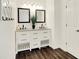 Well-lit bathroom featuring a double vanity with dark wood framed mirrors, and modern fixtures at 6298 Briargate Dr, Zionsville, IN 46077