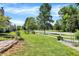 Spacious front yard featuring lush green grass, a white picket fence, and mature trees under a blue sky at 6298 Briargate Dr, Zionsville, IN 46077