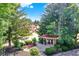 Beautiful community park area with mature trees, a red park bench, and a covered picnic structure at 6402 Friendship Cir, Indianapolis, IN 46268