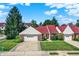 Charming home with a well-manicured lawn, a red roof and an attached two-car garage at 6402 Friendship Cir, Indianapolis, IN 46268