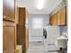 Functional laundry room boasts a modern washer and dryer, wood cabinets and a sink at 6402 Friendship Cir, Indianapolis, IN 46268