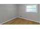 This bedroom features hardwood floors, light grey wooden paneled walls, and natural light at 6430 N Rural St, Indianapolis, IN 46220