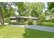 A single story home with a chimney, stone driveway and beautiful lawn surrounded by lush trees at 6430 N Rural St, Indianapolis, IN 46220