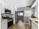 Modern kitchen features white cabinets, stainless steel appliances and woodgrain floors at 6430 N Rural St, Indianapolis, IN 46220