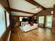 Spacious living room featuring a beamed ceiling, hardwood floors, and brick fireplace at 6430 N Rural St, Indianapolis, IN 46220