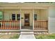 Inviting front porch with wooden railing, decorative pillars and a wood door at 696 W Mill St, Danville, IN 46122