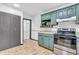 Cozy kitchen features vintage teal cabinetry, stainless steel appliances, and neutral countertop space at 696 W Mill St, Danville, IN 46122