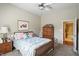 Carpeted bedroom with ceiling fan and view into en suite bathroom at 712 Disciples Way, Greenwood, IN 46143