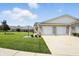 Well-maintained townhome exterior featuring a two-car garage and lush front lawn at 712 Disciples Way, Greenwood, IN 46143