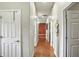 Long hallway with wood floors, featuring several doorways and decorative wall art at 712 Disciples Way, Greenwood, IN 46143