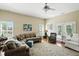 Bright living room features hardwood floors, a ceiling fan, and many windows at 712 Disciples Way, Greenwood, IN 46143